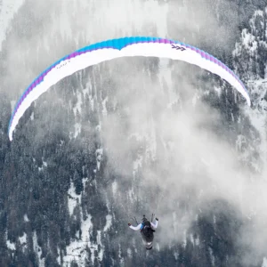 Ski photography journal: speed rider flying a canopy over an Arlberg rock face