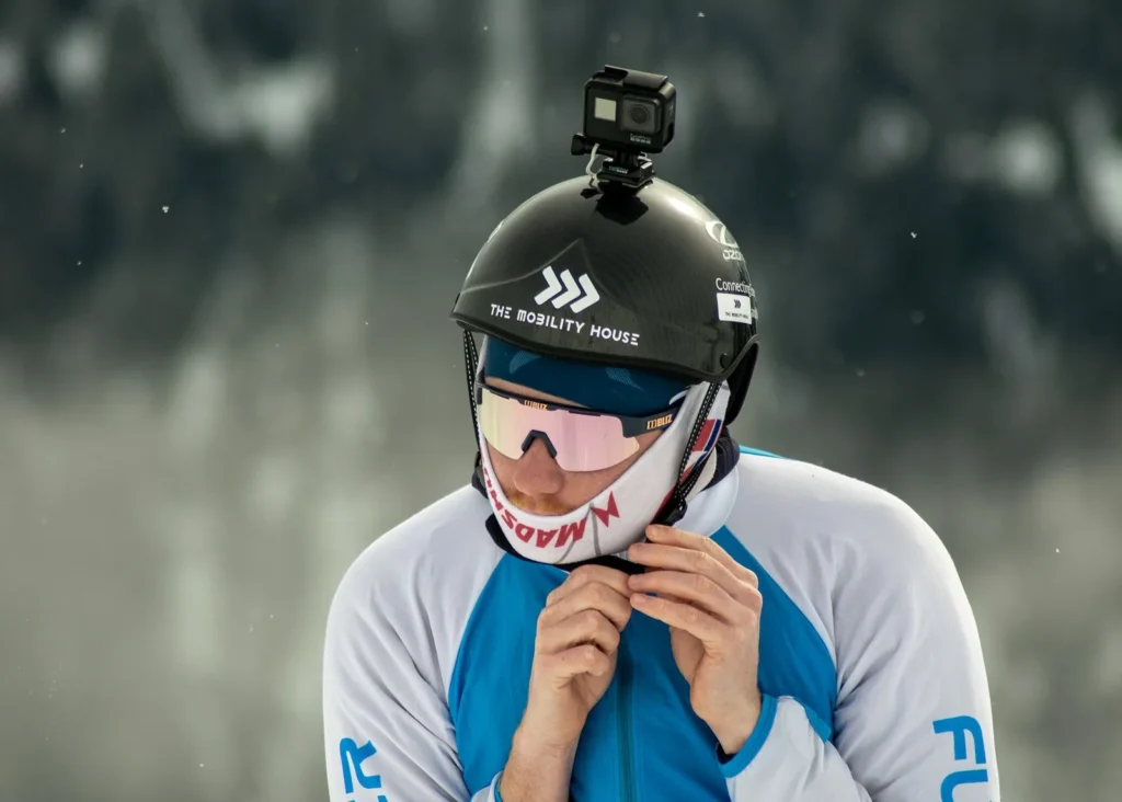 Professional ski photography vs a GoPro: skier fastening a helmet with a GoPro on top