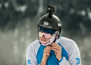 Professional ski photography vs a GoPro: skier fastening a helmet with a GoPro on top